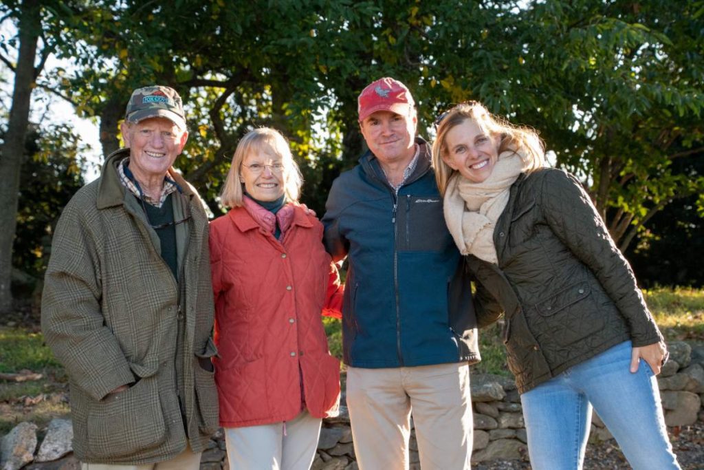 people hugging and posing for a photo dressed in countryside attire