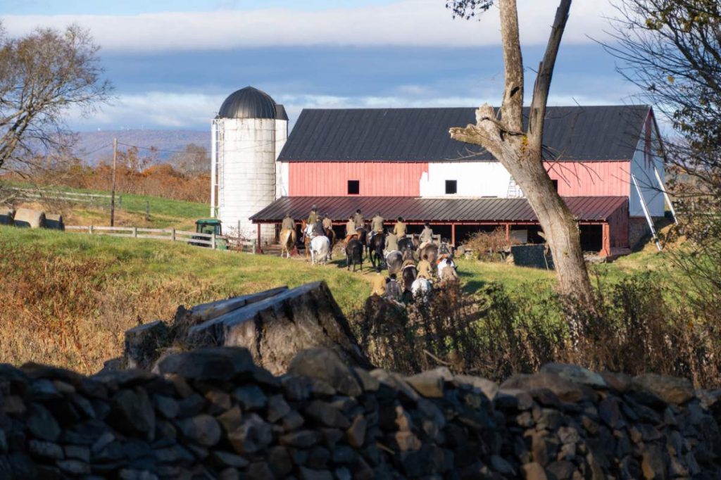 barn with riders approaching on a cubbing day